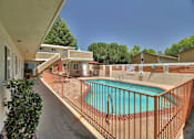 Thumbnail 5 of 21 - a swimming pool with a wrought iron fence around it