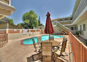 Thumbnail 6 of 21 - a patio with a pool and a table with chairs