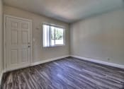 Thumbnail 11 of 21 - an empty living room with a door and a window