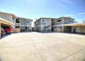 Thumbnail 10 of 26 - an empty parking lot in front of a row of houses