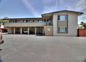 Thumbnail 8 of 63 - A building with a parking lot in front of it.
