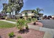 Thumbnail 5 of 63 - A building with a driveway and a tree in front.