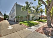 Thumbnail 4 of 42 - A street view of a green building with a white arrow on the road.