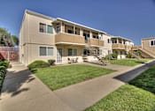 Thumbnail 10 of 33 - Apartment complex with a green lawn in front.