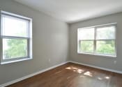 Thumbnail 13 of 27 - an empty room with two windows and a hardwood floor