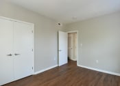 Thumbnail 15 of 27 - a bedroom with white walls and hardwood floors