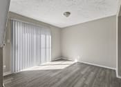 Thumbnail 9 of 47 - A room with a window covered by white blinds and wooden flooring.