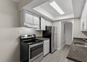 Thumbnail 11 of 47 - A kitchen with black appliances and white cabinets.