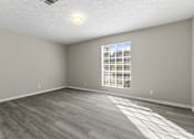 Thumbnail 7 of 47 - A room with a window and a wooden floor.