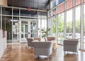 Thumbnail 2 of 16 - A room with grey chairs and a glass wall.