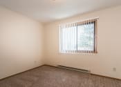 Thumbnail 8 of 12 - Grand Forks Kremer Apartments a bedroom with a large window and carpet
