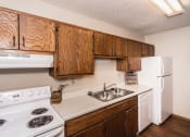 Thumbnail 7 of 12 - Grand Forks Kremer Apartments a kitchen with white appliances and wooden cabinets