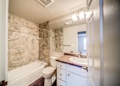 Thumbnail 24 of 29 - Tiled Bathroom with Tub and White Cabinets