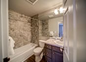 Thumbnail 23 of 29 - Tiled Bathroom with Tub and Dark Cabinets