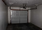 Thumbnail 13 of 13 - A garage with a white door and a white ceiling.