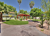 Thumbnail 15 of 17 - A red pavilion is in the middle of a courtyard with palm trees.