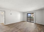 Thumbnail 12 of 24 - an empty living room with a sliding glass door to a balcony