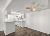 Thumbnail 10 of 24 - the living room and kitchen of an apartment with a ceiling fan