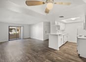 Thumbnail 13 of 24 - an empty kitchen and living room with a ceiling fan
