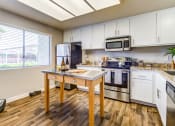 Thumbnail 15 of 21 - Aliso Viejo Apartments for Rent - Aliso Creek - Kitchen with Stainless-Steel Appliances, White Cabinets, Garden Style Windows, and Kitchen Island at Aliso Creek, California, 92656