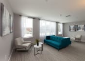 Thumbnail 18 of 24 - Sun-filled living space featuring teal accent furniture and large windows