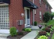 Thumbnail 2 of 16 - A brick building with a white door and a sign that says