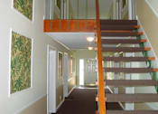 Thumbnail 5 of 16 - A staircase with a wooden handrail and a carpeted floor.