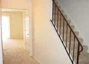 Thumbnail 9 of 16 - A staircase with a metal railing and a carpeted floor.