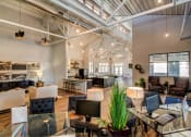 Thumbnail 13 of 65 - Leasing Office and Clubhouse with White Armchairs on Area Rug with Coffee Tables at Aviator at Brooks, San Antonio, Texas