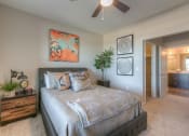 Thumbnail 32 of 78 - bedroom with ceiling fan and hallway to the bathroom  at EdgeWater at City Center, Lenexa, KS