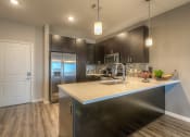 Thumbnail 26 of 78 - a kitchen with a large counter space and stainless steel appliances  at EdgeWater at City Center, Lenexa, 66219