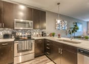 Thumbnail 27 of 78 - a kitchen with stainless steel appliances and white countertops  at EdgeWater at City Center, Lenexa, KS, 66219