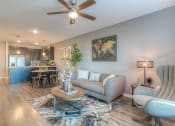 Thumbnail 30 of 78 - a living room with a ceiling fan and chair  at EdgeWater at City Center, Lenexa, Kansas