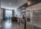 Thumbnail 57 of 78 - a kitchen with stainless steel appliances and a wooden floor  at EdgeWater at City Center, Lenexa, KS, 66219