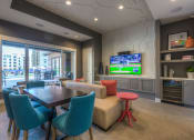 Thumbnail 44 of 78 - a resident clubhouse with a table and chairs and a flat screen tv at EdgeWater at City Center, Lenexa, KS, 66219