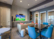 Thumbnail 45 of 78 - a room with a table and chairs and a tv  at EdgeWater at City Center, Lenexa, KS