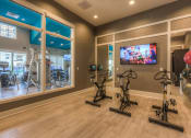 Thumbnail 48 of 78 - the gym with stationary bikes and a tv  at EdgeWater at City Center, Lenexa