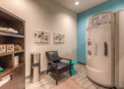 Thumbnail 50 of 78 - a room with a chair and tanning bed  at EdgeWater at City Center, Lenexa, KS, 66219