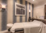 Thumbnail 51 of 78 - a room with a massage bed and a painting on the wall  at EdgeWater at City Center, Lenexa, KS