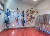 Thumbnail 56 of 78 - a bike rack with several bikes on the wall and a bench with a metal bench in front  at EdgeWater at City Center, Lenexa, KS, 66219