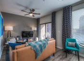 Thumbnail 60 of 78 - a living room with gray walls and a ceiling fan  at EdgeWater at City Center, Lenexa, KS, 66219