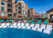 Thumbnail 5 of 78 - loungers in pool and umbrellas with chairs  at EdgeWater at City Center, Kansas
