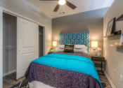 Thumbnail 62 of 78 - a bedroom with a large bed and a ceiling fan  at EdgeWater at City Center, Lenexa, 66219