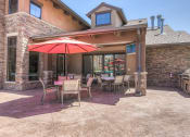 Thumbnail 15 of 78 - a patio with a grill and tables with umbrellas at EdgeWater at City Center, Lenexa, KS