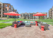 Thumbnail 18 of 78 - an outdoor lounge area with umbrellas and apartments in background  at EdgeWater at City Center, Lenexa, 66219