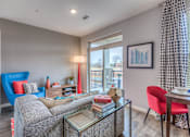 Thumbnail 43 of 53 - a living room with a couch and a table and a window  at Waterside Residences on Quivira, Lenexa