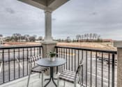 Thumbnail 46 of 53 - a balcony with a table and chairs and a view of a parking lot  at Waterside Residences on Quivira, Lenexa, 66215