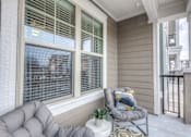 Thumbnail 40 of 53 - a covered porch with a chair and a window  at Waterside Residences on Quivira, Lenexa, KS, 66215