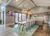Thumbnail 21 of 53 - community kitchen with a large island and a table with chairs  at Waterside Residences on Quivira, Lenexa, KS