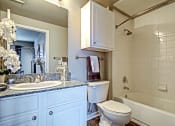 Thumbnail 12 of 37 - bathroom in one bedroom floorplan with white cabinets and granite countertops